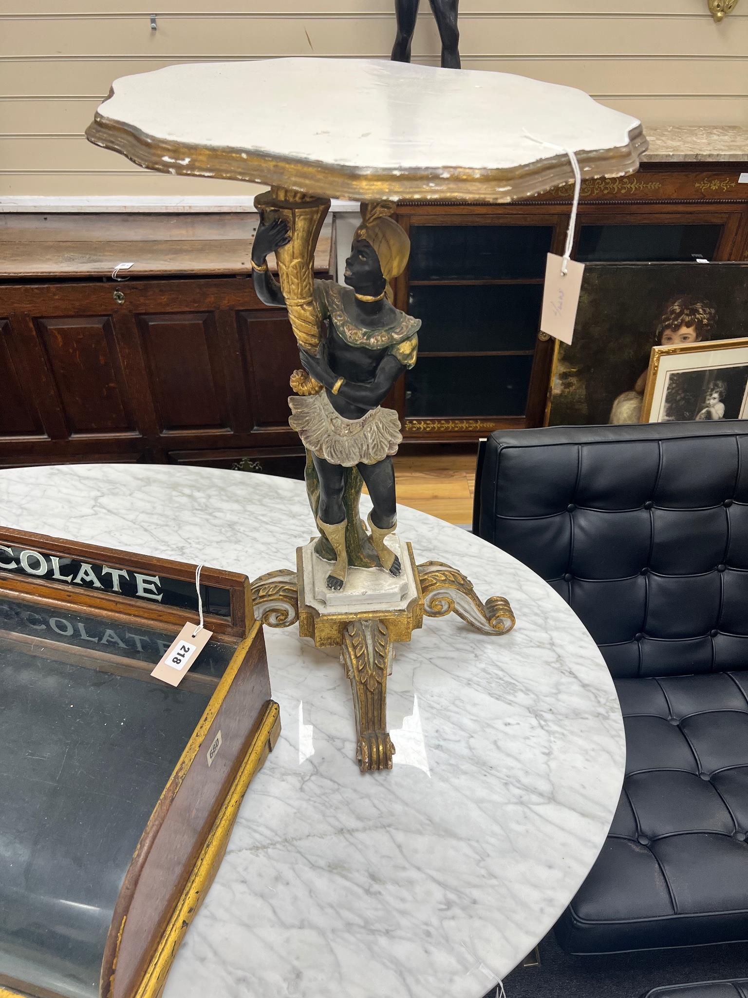 A carved painted wood blackamoor occasional table, width 50cm, height 72cm.